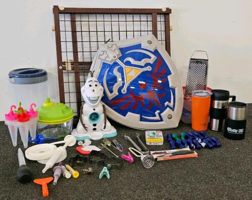 (XB) Mixed Collectible and Kitchen Lot: Legend of Zelda Shield Backpack, 3 Assorted Tupperwares, Plastic Pitcher, 3 Assorted Travel Coffee Mugs, Olaf Snowcone Maker, Popsicle Mold, Cheese Grater and Cheese Knife, Two Paring Knives, Baby Gate, 8 Sets of Co