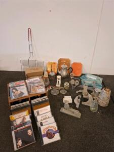 Vintage kitchenware. Coffee/tea pot. Salt and pepper shaker, meat grinder, vintage stapler. Camping cooking rack. Box of cds, such as bing Crosby, Garth brooks and more