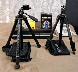 (2) Camera Tripods W/ Storage Bags, (1) AA / AAA Battery Charger, (1) Mini Plasma Light, (1) 3-Drawer Cassette Tape Cabinet W/ (20+) Assorted Tapes & (1) At&T Home Phone