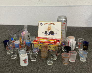 Assortment Of Shot Glasses, Cocktail Sticks, And Drink Shaker