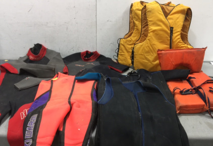 (5) Wetsuits of Various Sizes, (3) Life Vests