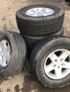 (1) Goodyear Wrangler Tire, (4) DeanTires All-Terrain Back Country, & (5) Jeep Rims
