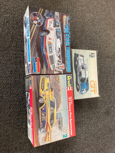 2 model cars and on box of parts