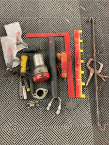 Medium Box of Assorted Tools and Parts: Pneumatic Grinder, Drain Cover, Flashlight, Unknown Press, Metal and Plastic Components, Handles, Socket,’plus more