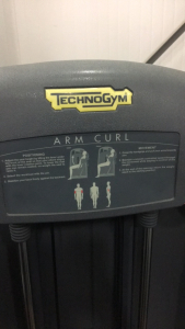 (1) TechnoGym Arm Curl Weight Machine
