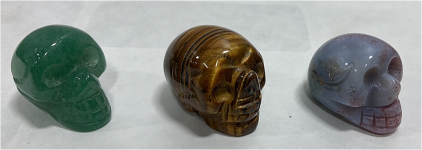 (1) Carved Tiger Eye Crystal Skull 82.25 Carat, (1) Carved Moss Agate Carnelian Crystal Skull 61.45, (1) Carved Adventurine Crystal Skull 62.5 Carat