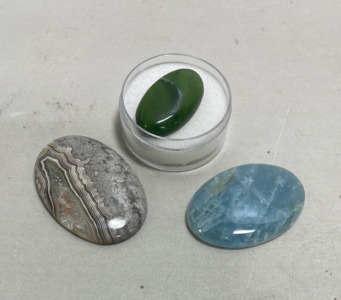 (1) Stunning Aquamarine Oval Cabochon Gemstone 57.80ct, (1) Crazy Lace Agate Cabochon Gemstone 73.15ct, (1) Serpentine Jade Cabochon Gemstone 25.45ct