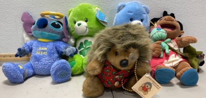 (1) Little Angel Disney Park Store Exclusive Stitch Stuffed Animal, (1) Lilo From Lilo and Stitch Stuffed Animals (2) New With Tag Care Bear Stuffed Animals, and (1) Lord Hedgely Stuffed Animal New With Tags