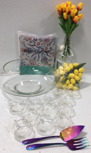 (1) Large Punch Bowl (12) Glass Punch Cups (1) Artificial Tulip Bouquet (1) Large Glass Jug (1) 54”x108” Tablecloth (1) Multi Colored Serving Utensils (1) Artificial Lemons