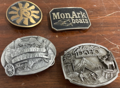 (1) Sun RS Belt Buckle, (1) MonArk Boats Belt Buckle, (1) &ldquo;Proud To be A Veteran&rdquo; Belt Buckle, (1) Celebrate Idaho Belt Buckle