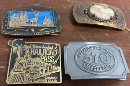 (1) Blue Deer Belt Buckle, (1) Marble and Dark Brown Metal Belt Buckle, (1) Bob RailRoads Pass Casino Supper Club Belt Buckle, (1) Operating Engineers 370 Spokane Belt Buckle