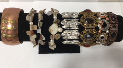 (1) Bronze Costume Fashion Bracelet Cuff (1) Silver Stretch Bracelet (1) Bronze Stretch Bracelet w/ Large Brown Stones and Small Brown, Green, and Yellow Stones (1) Stretch Bronze Bracelet w/ Ruby Colored Stones (1) Silver and Bronze Stretch Bracelet (3) 