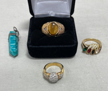 (1) Gold Toned Tigers Eye And Clear Gemstone Ring Size 12, (1) Gold Toned Multicolored Gemstone Ring Size 7, (1) Gold Toned Clear Gemstone Ring Size 4-1/2, (1) Green Gemstone Pendant