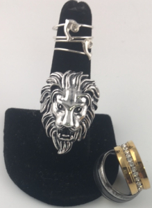 (1) Size 8.5 Men&rsquo;s Charcoal Colored Band ; (1) Size 9-9.5 Silver Lion Head Eimg ; (1) Size 6.5-7 Gold w/ Diamonds Ring ; (2) size 4 Silver w/ Dolphin Rings
